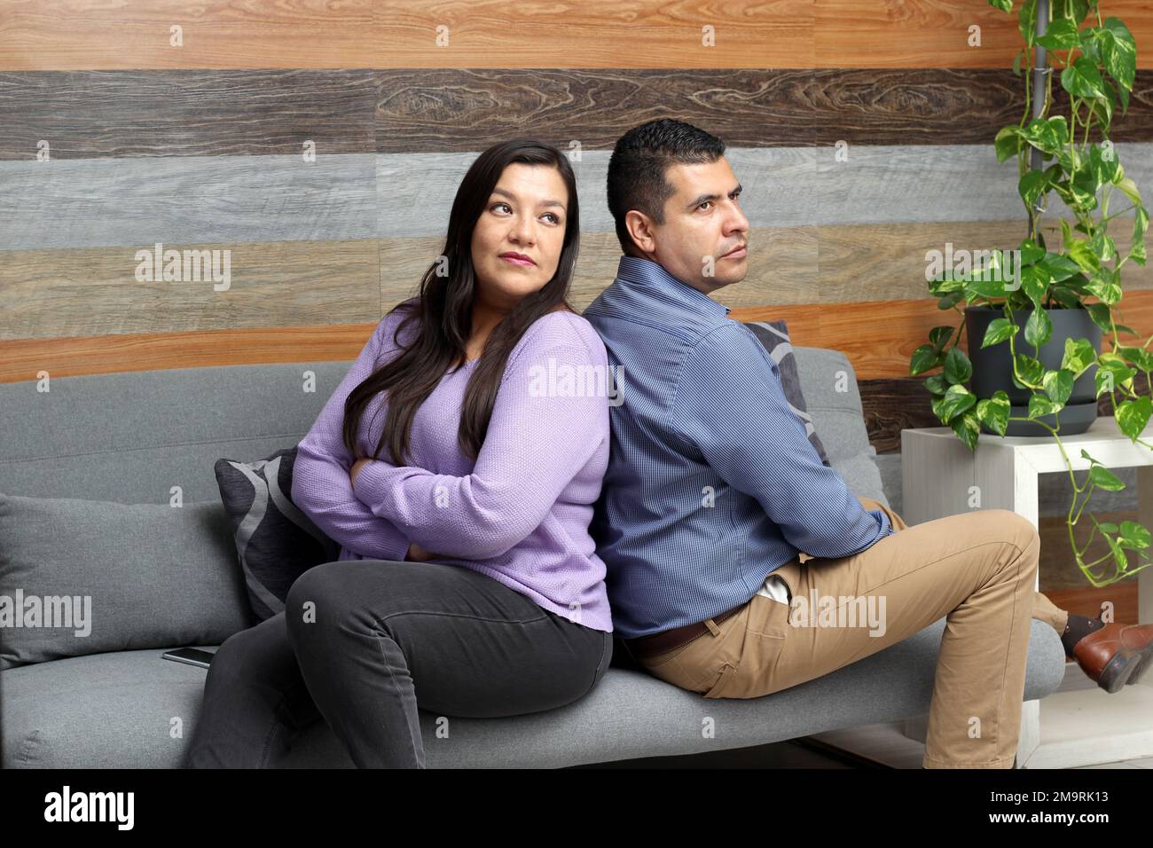 Ein erwachsenes Paar aus Latino, das auf dem Sofa sitzt, ist verärgert und wütend über Probleme, die zu ihrer Trennung führen können Stockfoto