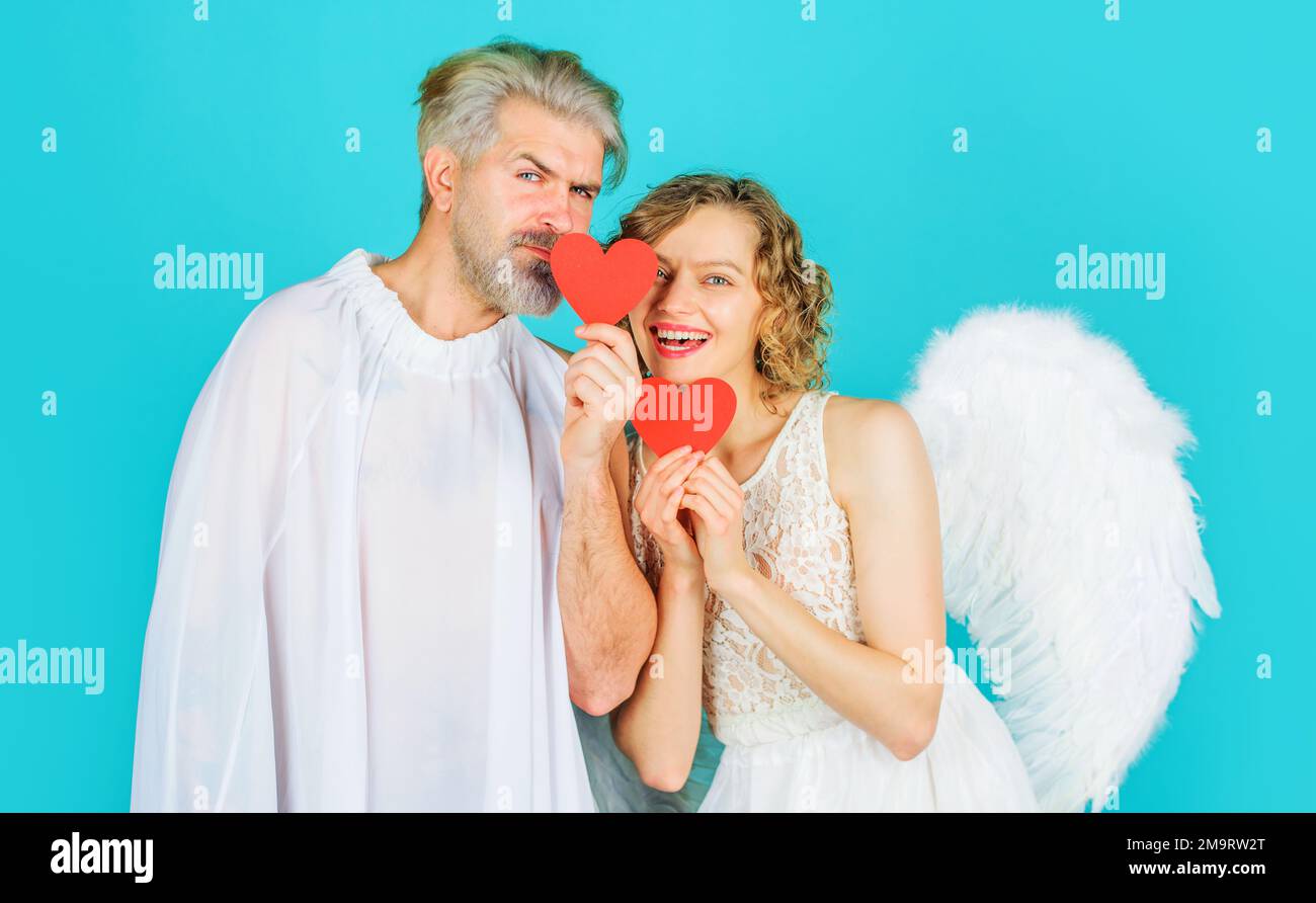 Valentinstag-Paar in Engelsflügeln. Amor-Engel mit rotem Papierherz. Valentinskarte. Stockfoto