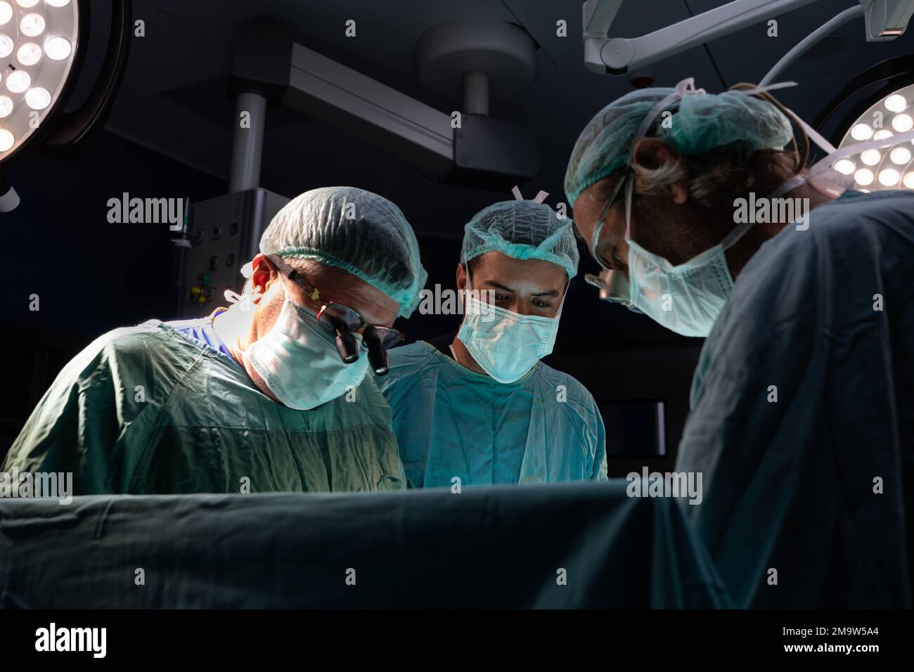 Chirurgie am offenen Herzen Arzt führt Operation am offenen Herzen durch. Ärzte in grünen Uniformen sind im Operationssaal Stockfoto