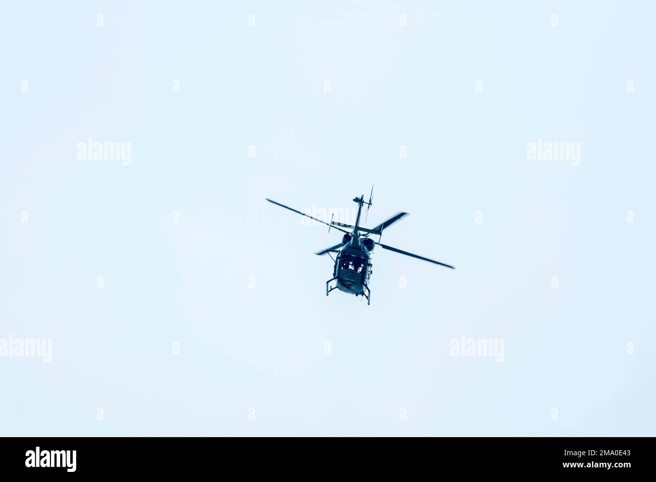 Fliegender Hubschrauber gegen den isolierten blauen Himmel. Stockfoto