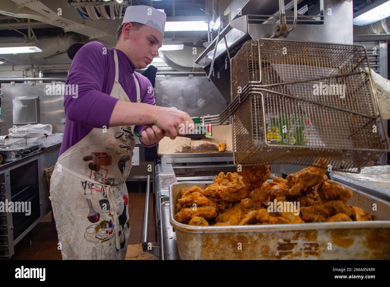 220522-N-TO573-1057 MITTELMEER (Mai 22 2022) Spezialist für Meeresfrüchte Ivan Walker, aus Eugene, Oregon, Frites Chicken in einer Galerie an Bord der USS Harry S. Truman (CVN 75), 22. Mai 2022. Die Harry S. Truman Carrier Strike Group befindet sich in einem geplanten Einsatz in den USA Marinestreitkräfte Europa Einsatzgebiet, angestellt von den USA Sechste Flotte, die die Interessen der USA, Allied und Partner verteidigt. Stockfoto