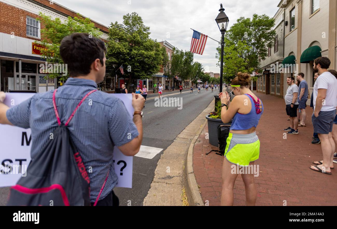 Zuschauer jubeln die Rennteilnehmer während der 15. Jahreshälfte des Marine Corps Historic Half (MCHH) an, während sie durch die historischen Straßen von Fredericksburg, Virginia, laufen, am 22. Mai 2022. The Historic Half ist ein 13,1 km langes Rennen, bei dem etwa 4.000 Teilnehmer zur Förderung der körperlichen Fitness, zur Schaffung von Wohlwollen in der Gemeinde und zur Präsentation der organisatorischen Fähigkeiten des Marine Corps eingeladen wurden. Die Veranstaltung umfasste auch die Semper Five, 5 Meilen, und das Devil Dog Double, 18,1 Meilen. Stockfoto