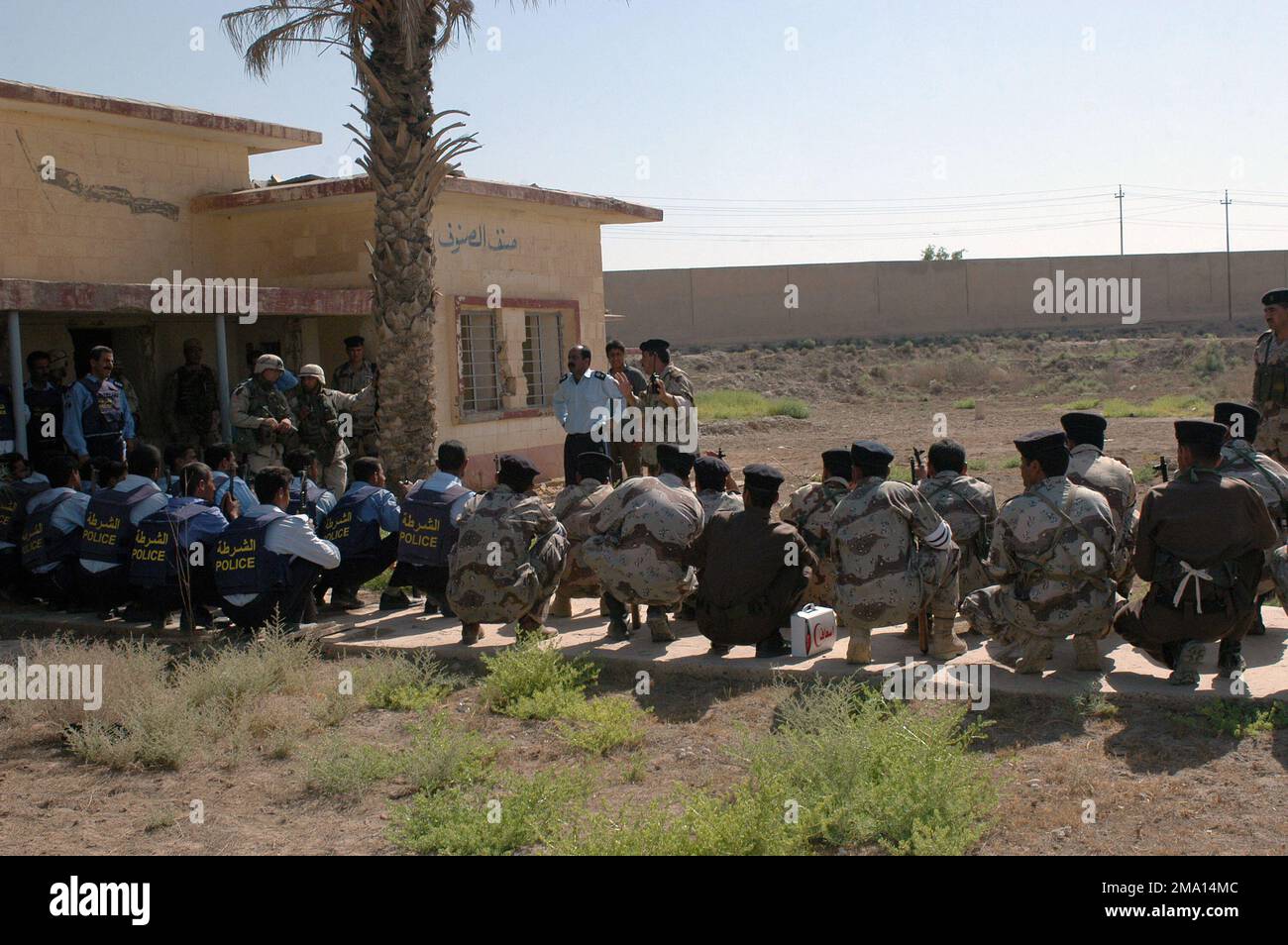 040606-M-5555L-123. [Complete] Szene Caption: Soldaten des irakischen Zivilschutzkorps (ICDC) und Offiziere der irakischen Polizei (IP), bewaffnet mit 5,56-mm-Tabuk-Sturmgewehren, versammeln sich, um einen Bericht über die Nachaktion anzuhören, der vom irakischen Oberstleutnant Salah, POLIZEICHEF der irakischen Polizeistation Al Horeiya, verfasst wurde. Akarm, Major (MAJ) des irakischen Zivilschutzkorps (ICDC), S-3 Offizier, der der 501. Brigade zugewiesen wurde, im Anschluss an die Razzia des Praxishauses, die in der Nähe des Camp Hurricane Point durchgeführt wurde, am Stadtrand von Ar Ramadi, Irak. SOLDATEN DER US-Armee (USA), die dem US Marine Corps (USMC) 1. Marine Divis angeschlossen sind Stockfoto