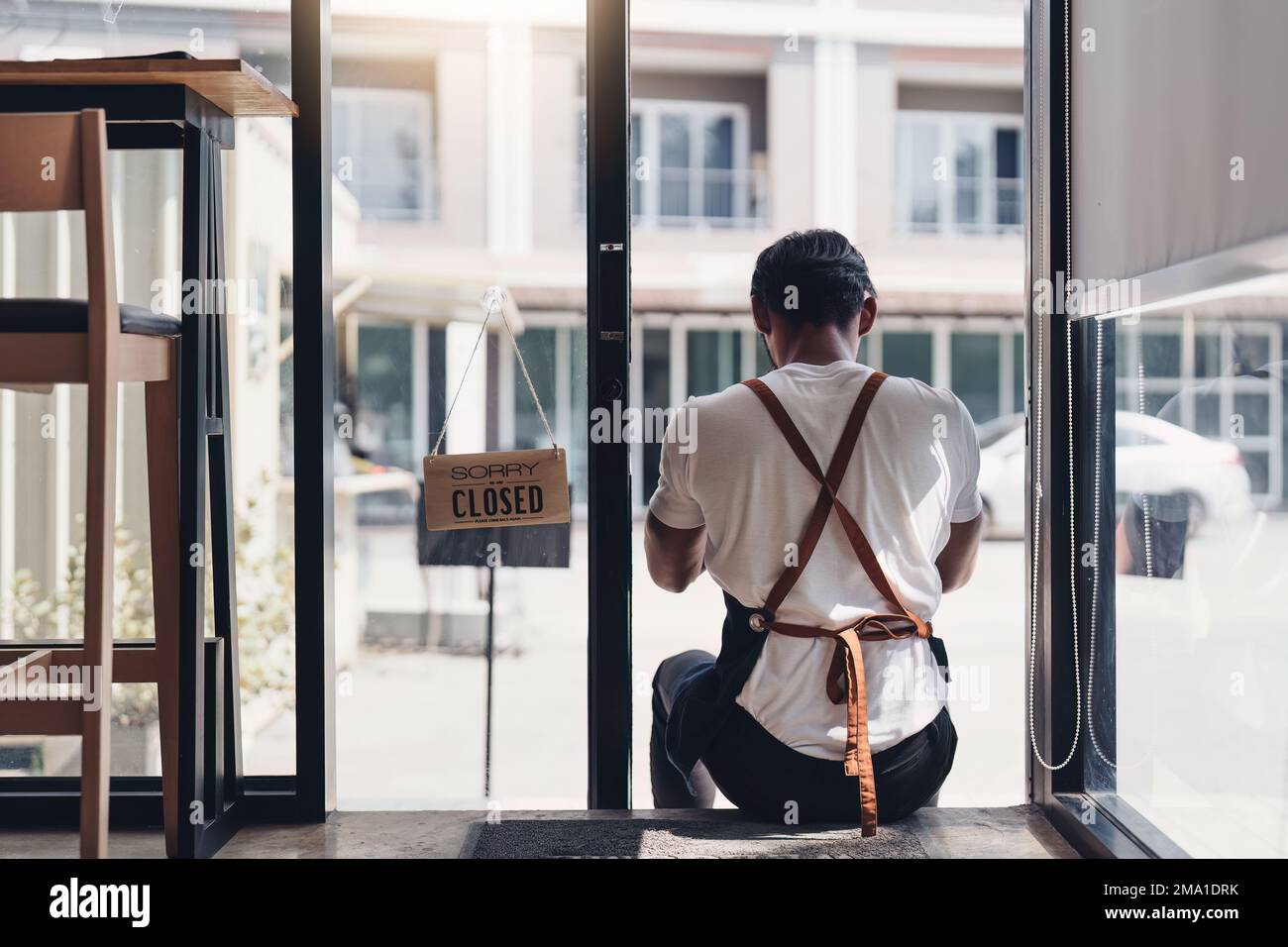 Junger Manager im Restaurant. Mann, Coffee Shop-Besitzer mit Schliessschild. Konzept für kleine Unternehmen Stockfoto