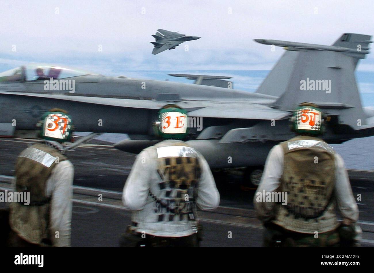 040628-N-6213R-061. [Complete] Scene Caption: US Navy (USN) Flightdeck Personal Sehen Sie sich an, wie ein USN F-14D Tomcat, Fighter Squadron Three One (VF-31), Tomcatters, zusammen mit dem Nimitz Class Aircraft Carrier USS JOHN C. STENNIS (CVN 74) einen Hochgeschwindigkeitsflug durchführt. STENNIS und Carrier Air Wing 14 (CVW-14) nehmen am Rim of the Pacific (RIMPAC) 2004 Teil. RIMPAC ist die größte internationale Seefahrt-Übung in den Gewässern rund um die hawaiianischen Inseln. Dieses Jahr sind sieben teilnehmende Länder beteiligt: Australien, Kanada, Chile, Japan, Südkorea, Vereinigtes Königreich und United Stat Stockfoto