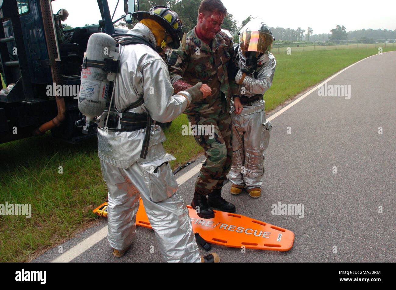 040817-F-0629H-009. [Complete] Szene Caption: 040817-F-0629H-009 (17. Aug. 2004)Firefighters Gregory Farley (links) und US Air Force (USAF) SENIOR AIRMAN Brandon Albrecht, beide mit dem 20. Bauingenieurschwadron (CES), Shaw Air Force Base (AFB), South Carolina (SC), in Joint Firefighter Integrated Response Ensembles (MOPP), 4 Postern (JFIRE) Entfernen Sie USAF MASTER Sergeant (MSGT) Rick Smith, 20. Aeromedizin-Dental-Geschwader, ein simuliertes Opfer, vom Tatort eines MARE-Szenarios auf der Patrouillenstraße am Stützpunkt. Notfalldienst ag Stockfoto