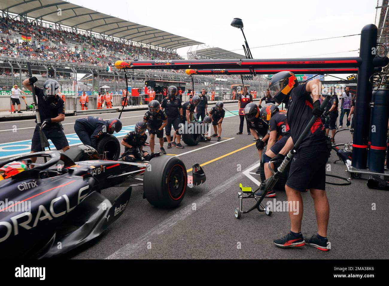 Pit crew work on Red Bull driver Sergio Perez's race car during a ...
