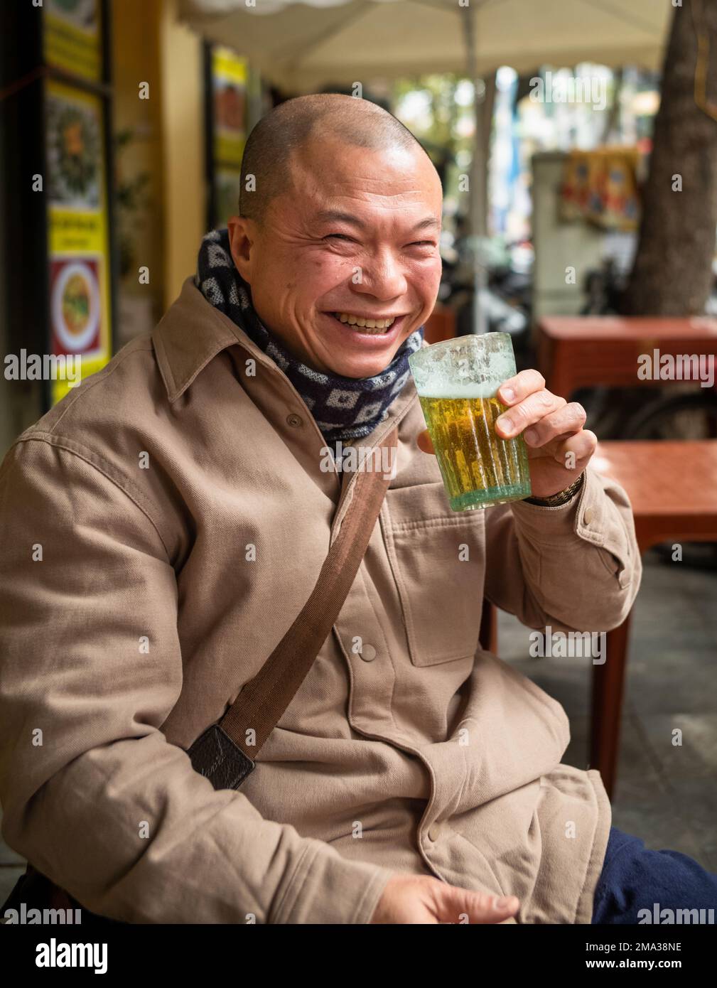 Ein vietnamesischer Mann trinkt ein Glas bia hoi oder frisches Bier auf ...