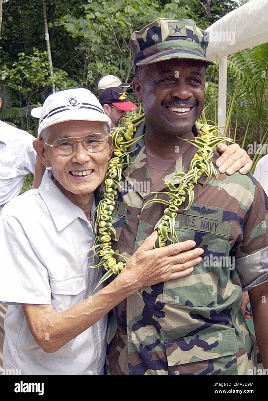 Kiyokazu Tsuchida (links), ehemaliger Soldat der japanischen Armee aus dem Zweiten Weltkrieg und Konteradmiral der US Navy (USN) (RADM) Arthur J. Johnson, Commander der US Naval Region Marianas, treffen sich bei einer Feier anlässlich des 60. Jahrestags der Schlacht von Peleliu auf der Insel Peleliu, Guam. Mr. Tsuchida, der 1944 auf der Insel stationiert war, versteckte sich fast zwei Jahre nach Kriegsende in den Höhlen und Dschungeln der Inseln und gab sich erst im April 1947 den amerikanischen Streitkräften hin. Basis: Peleliu Inselstaat: Guam (GU) Land: Vereinigte Staaten von Amerika (USA) Stockfoto