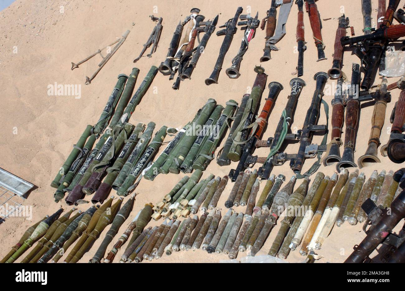 040921-M-2306K-032. [Complete] Scene Caption: Eine große Anzahl von Raketengranaten (RPG) (unten), RPG-7-Granatwerfer (oben) und RPG-18-leichten Anti-Panzerwaffen (Mitte, links), die von irakischen Sicherheitskräften während eines Überfalls eines Muqtada al Sadr-Unterschlupfes in einem Najaf, einer Najaf-Provinz, im Irak, gefunden wurden, werden von den USA ausgestellt Marine Corps Marines, 11. Marine Expeditionary Unit (MEU) Special Operations Capable, 21. September 2004. Diese Lager wurden in verschiedenen Gebäuden der Stadt gefunden und verstoßen unmittelbar gegen das Friedensabkommen zwischen dem Großayatollah Sayyid Ali Husaini al-Sistani, Stockfoto