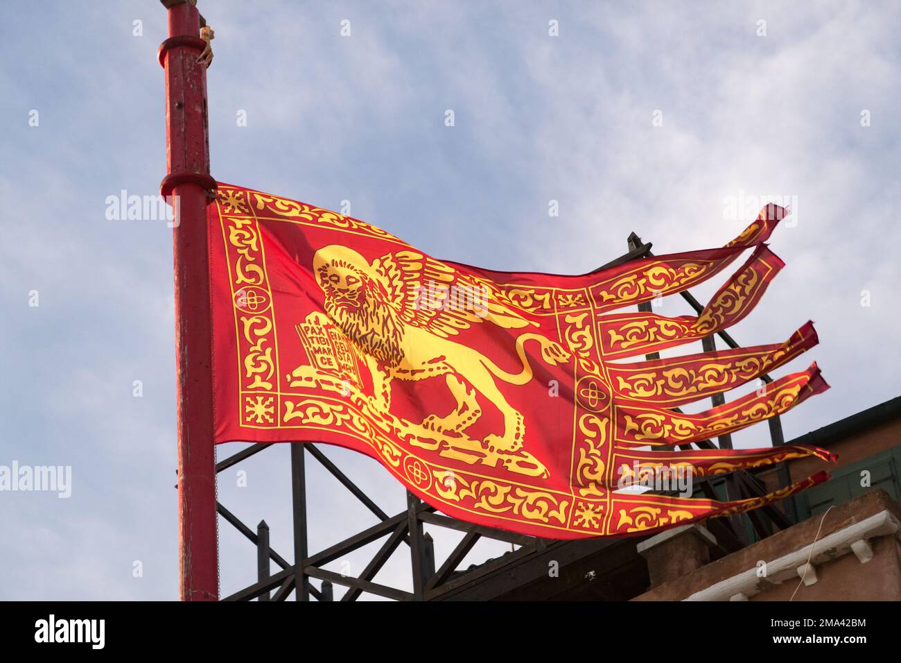 Die historische Flagge Venedigs, die auf einem Mast in der Nähe des Markusplatzes fliegt Stockfoto