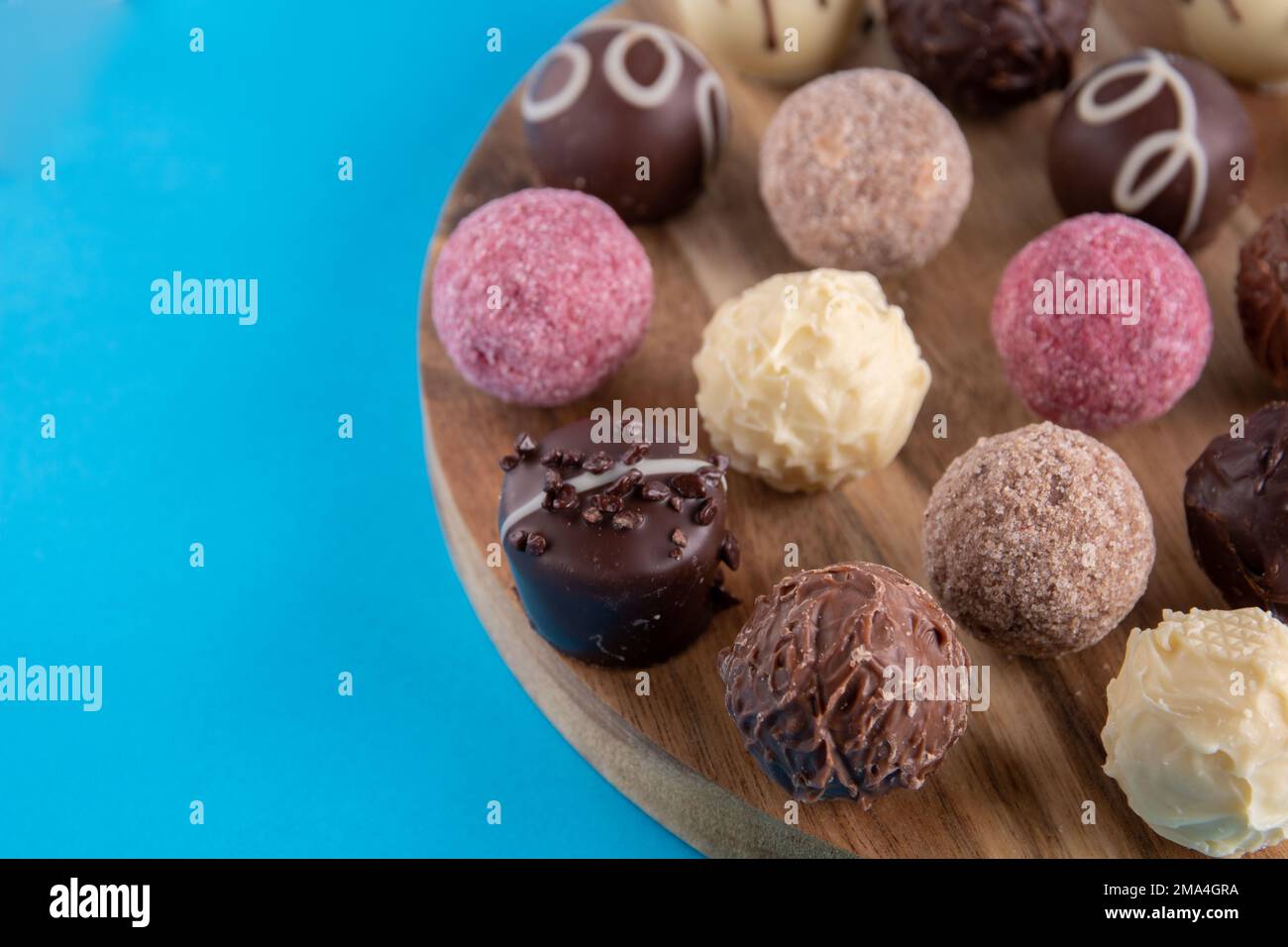 Runde Schokoladenbonbons auf einem runden Holzbrett Stockfoto