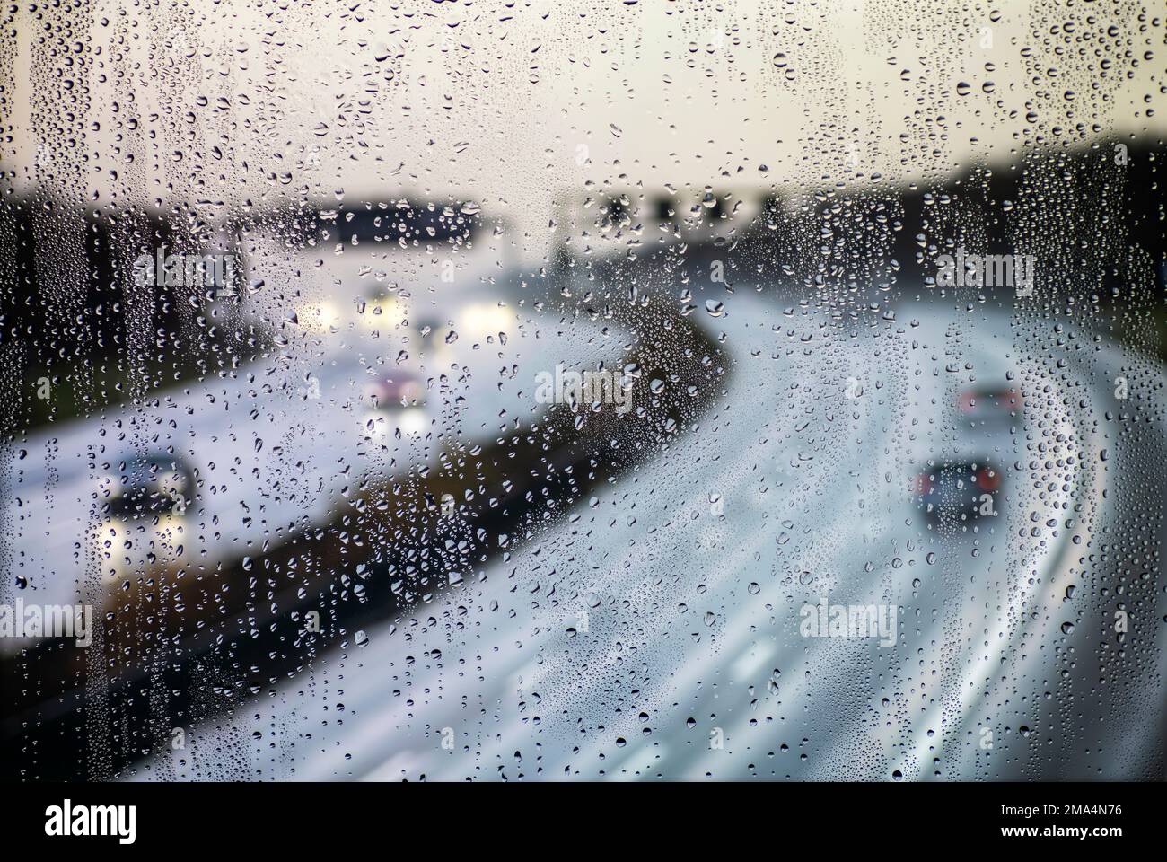 Blick durch ein regnerisches Fenster auf eine Autobahn Stockfoto
