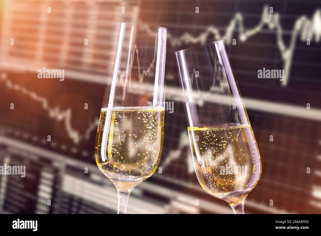Grund zum Feiern an der Börse. Champagnergläser und Monitor mit Börsenkursen im Hintergrund. Stockfoto