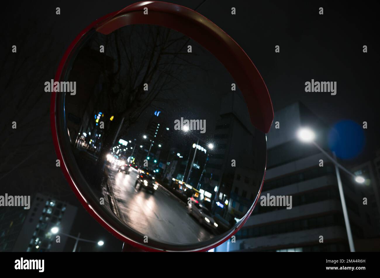 Abstraktes Hintergrundbild in der Nacht mit rundem Straßenspiegel, Nahaufnahme mit selektivem Fokus Stockfoto
