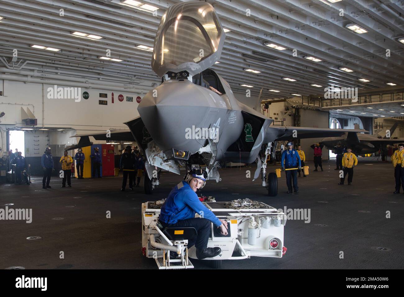 220525-N-IL330-1005 PAZIFIK (25. Mai 2022) – Airman Jacob Lavey aus Chesterfield, Mississippi, verwendet den Spürhütchen, um ein F-35B Lightning II-Flugzeug zu transportieren, das dem Marine Fighter Attack Squadron (VMFA) 121 in der Hangar Bay zugewiesen ist, an Bord des Amphibienflugzeugs USS Tripoli (LHA 7), 25. Mai 2022. Tripoli führt Routineeinsätze in der US-7.-Flotte durch. Stockfoto