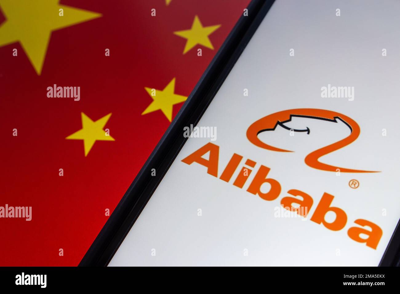 Das Logo von Alibaba auf einem iPhone auf Hintergrund mit chinesischer Flagge. Die Alibaba Group ist ein weltweit größtes Einzelhandels- und E-Commerce-Unternehmen in China. Stockfoto