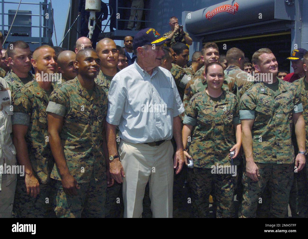 050220-N-5067K-050. [Complete] Szene Caption: Der ehemalige US-Präsident George H. W. Bush flankierte von Marines des US Marine Corps (USMC), während er für ein Foto an Bord des US Navy (USN) Whidbey Island Class Amphibious Dock Landing Ship USS FORT MCHENRY (LSD 43) posierte. USN-Matrosen und USMC-Marines begrüßten die ehemaligen US-Präsidenten William J. Clinton und George H. W. Bush, als sie verschiedene Orte an Bord des Schiffes bereisten und operative Briefings über die Beteiligung jeder Sektion an humanitären Hilfsmaßnahmen in Banda Aceh auf der Insel Sumatra, Indonesien, erhielten. FORT MCHENRY operiert gerade vor der Küste von Indo Stockfoto