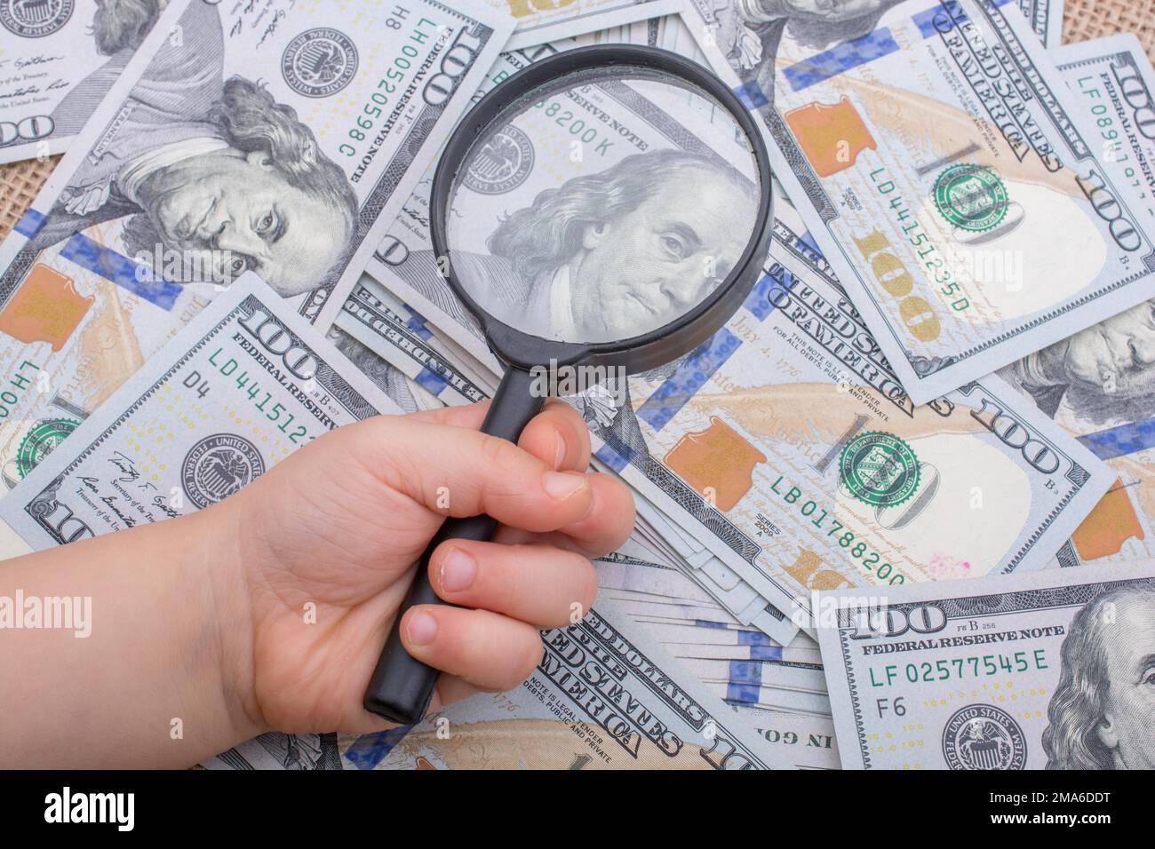 Lupe wird über die Banknote Bündel von US-Dollar gehalten. Stockfoto
