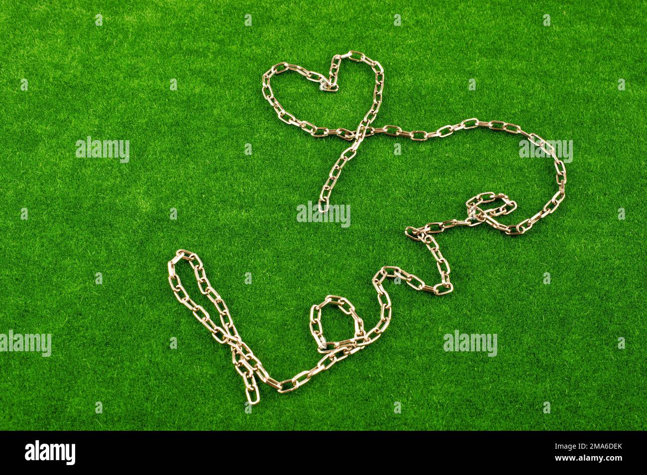 Kette schreibt das Wort Liebe auf dem grünen Rasen Stockfoto