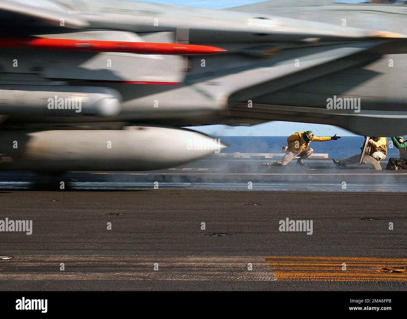 Ein US Navy (USN) Yellow Shirt Katapult Officer, hält seine Position, während er eines der letzten F-14B Tomcats-Flugzeuge startete, das den „Schwertmännern“ von FIGHTER Squadron Three Two (VF-32) vom Flugdeck der Nimitz-Klasse: Aircraft Carrier, USS HARRY S. TRUMAN (CVN-75) zugeteilt wurde. In der aktuellen Phase nimmt die F-14 Tomcat zum letzten Mal an Bord der Truman Teil. VF-32 wird in Kürze mit dem Übergang zum neuen F/A-18F Super Hornet-Flugzeug beginnen. Basis: USS Harry S. Truman (CVN 75) Land: Atlantik (AOC) Stockfoto