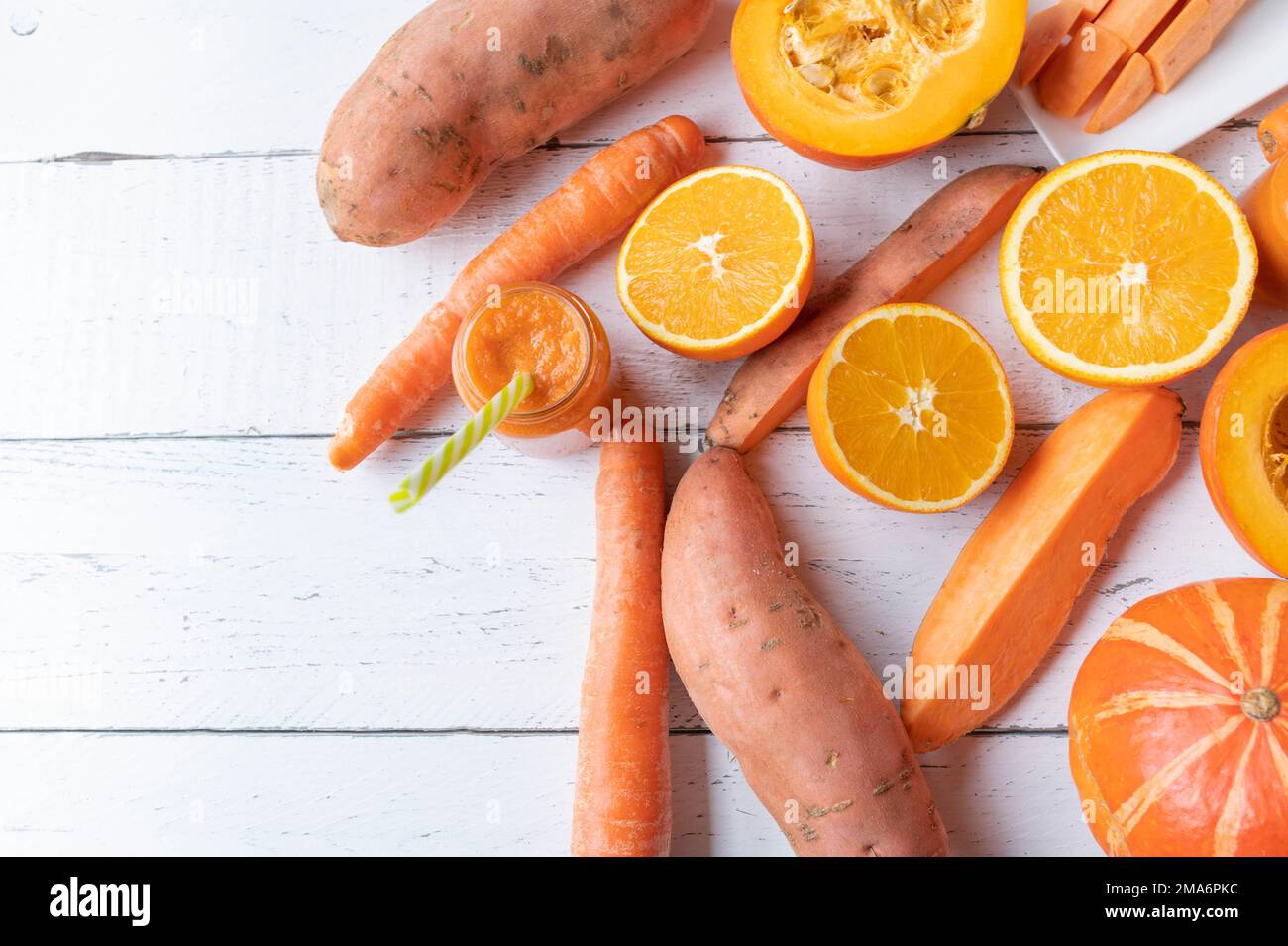 Orangefarbenes Gemüse und Früchte auf weißem Hintergrund. Flach liegend mit Platz für Text Stockfoto