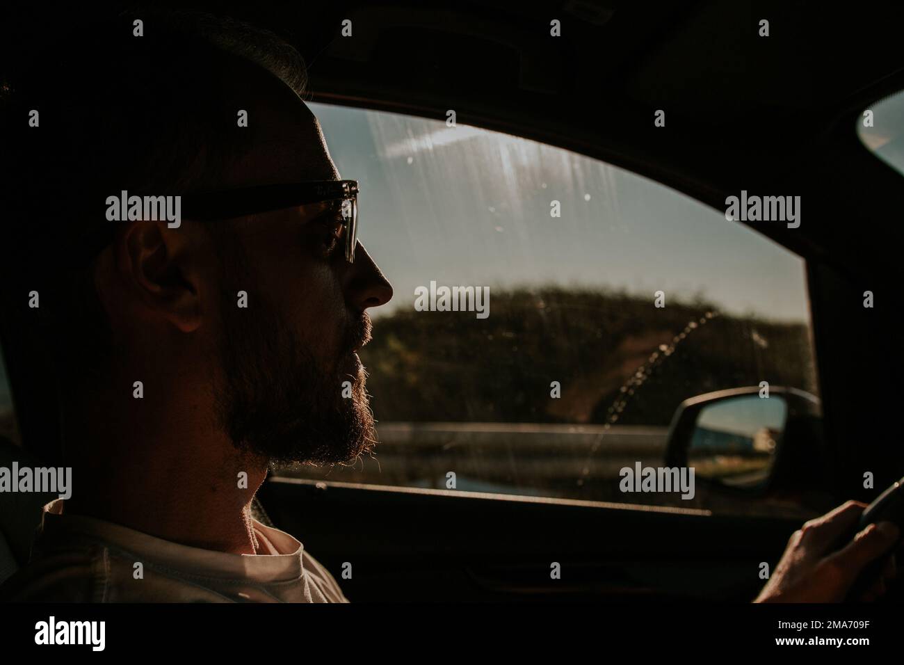 Ein Mann mit Brille fährt ein Auto Stockfoto