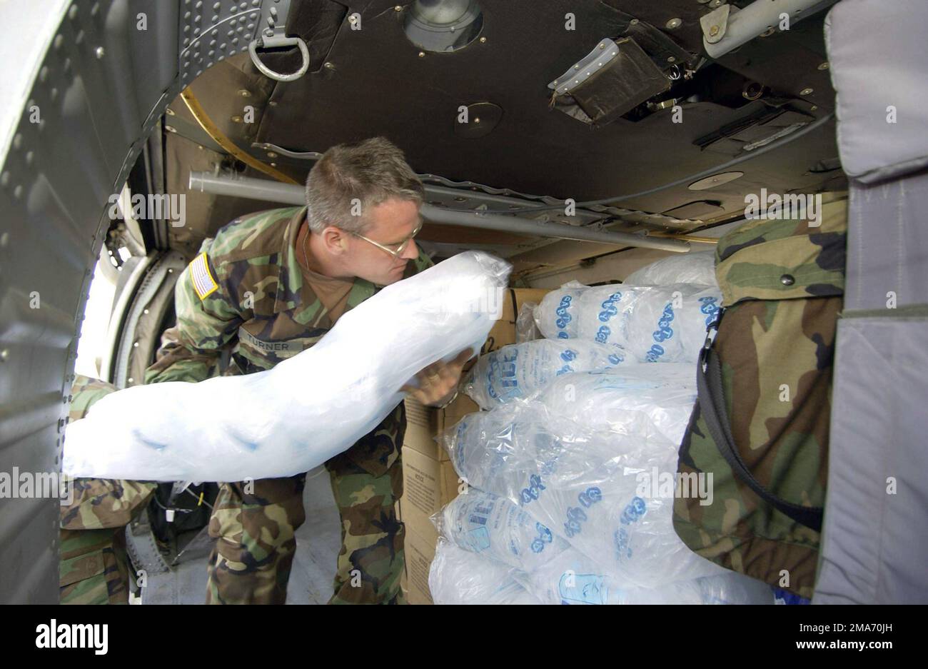 US Army (USA) National Guardsman SPECIALIST (SPC) Shawn Turner, vom 1. Bataillon, 131. Aviation Regiment, Mobile, Alabama (AL), Lädt eine Tasche Eis an Bord des USA UH-60 Black Hawk Hubschraubers auf den Luftwaffenstützpunkt der Luftwaffe (ANG), Mississippi (MS), zur Unterstützung der Hilfsmaßnahmen des Hurricane Katrina. Staat: Mississippi (MS) Land: Szene der Vereinigten Staaten von Amerika (USA) Hauptkommando: NATIONALGARDE DER ARMEE Stockfoto