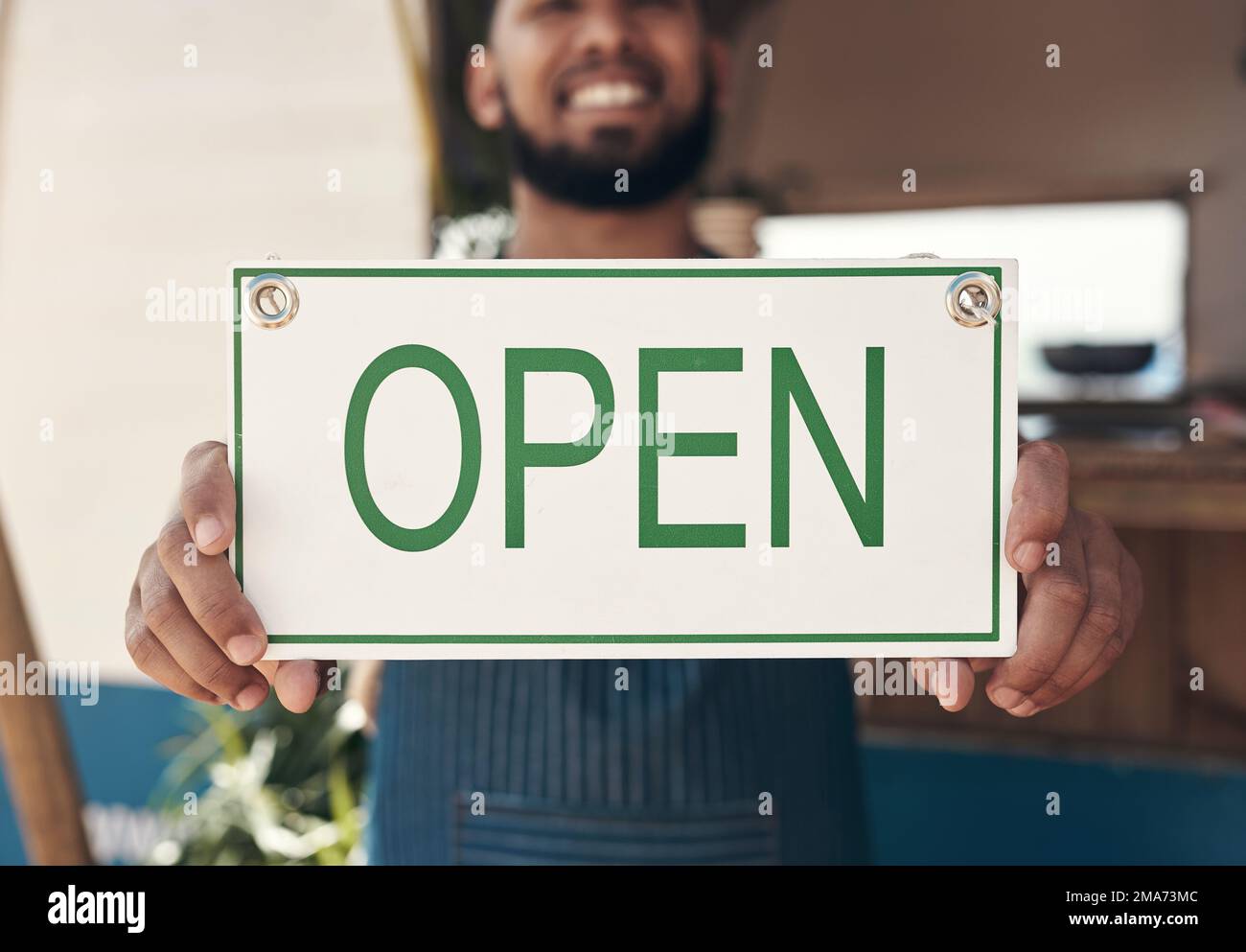 Offen und servierfertig. Ein Geschäftsmann, der ein offenes Geschäftsschild in der Hand hält. Stockfoto