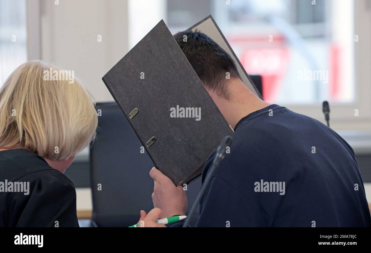 Rostock, Deutschland. 19. Januar 2023. Beate Falkenberg (l-r), Anwalt, und der Angeklagte im Triple-Mordprozess warten im Gerichtssaal auf die Fortsetzung des Prozesses. Der 27-jährige Mann soll im Februar letzten Jahres in Rövershagen seine Eltern und seine Schwester getötet haben. Kredit: Bernd Wüstneck/dpa/Alamy Live News Stockfoto