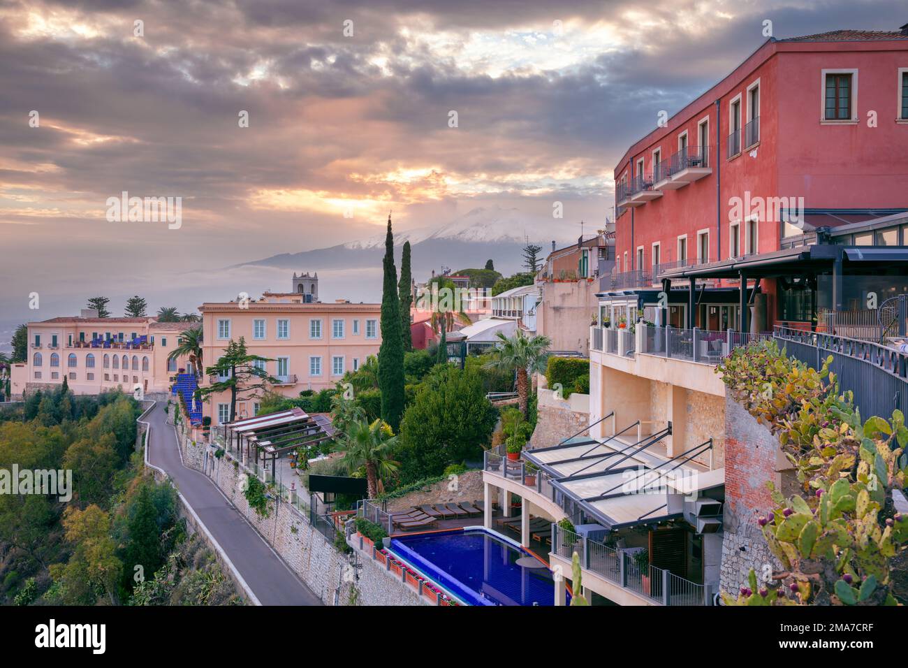 Taormina, Sizilien, Italien. Stadtbild der malerischen Stadt Taormina, Sizilien mit Vulkan Mt. Ätna im Hintergrund bei Sonnenuntergang. Stockfoto