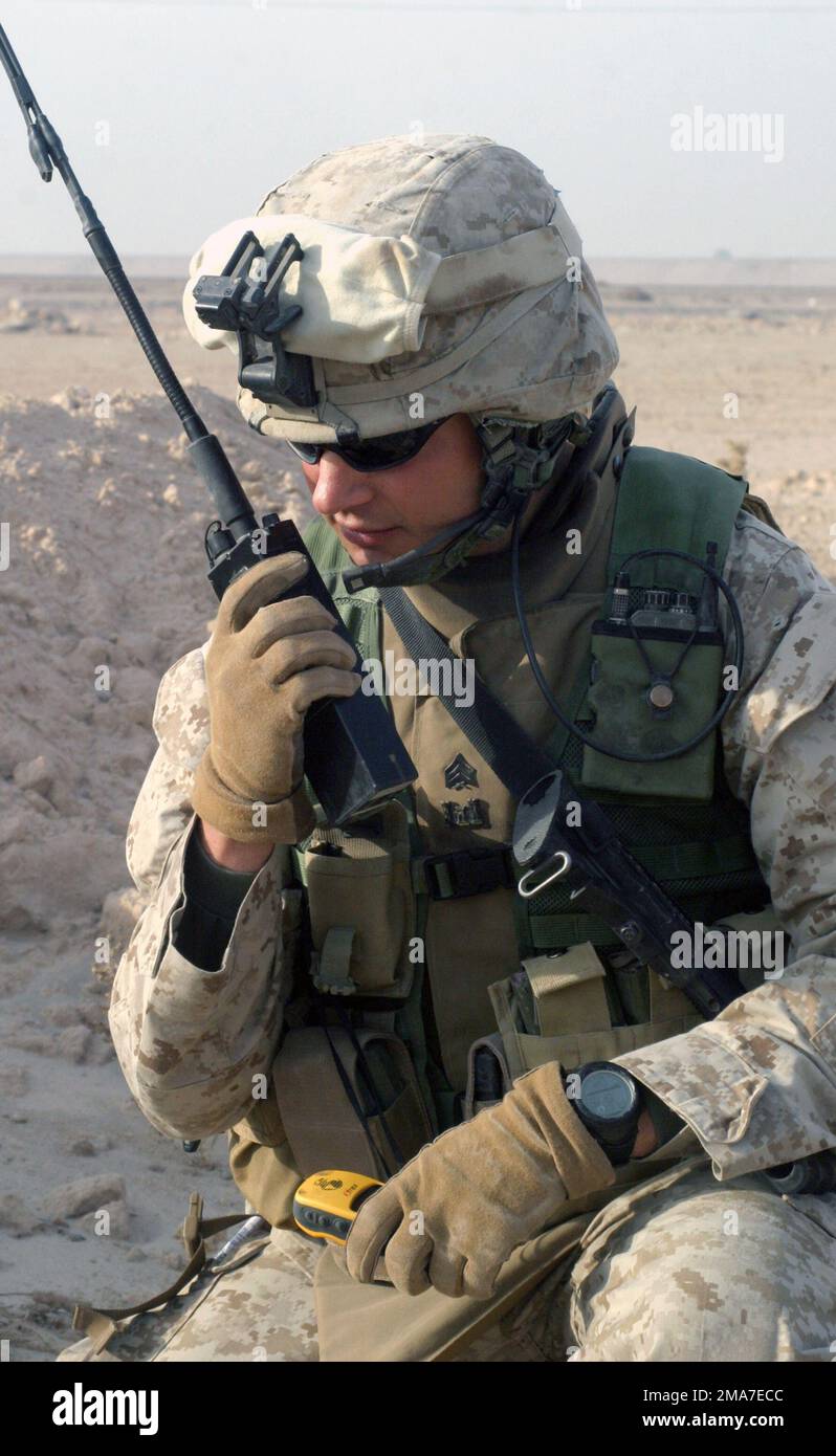 Sergeant Brandon Shofne, 2. Combat Engineers Battalion (CEB) des US Marine Corps (USMC), nutzt ein MBITR AN/PRC-148, um das Hauptquartier mit Beschreibungen der Kampfmittel zu erreichen, die während der Operation IRAQI FREEDOM in Kharma (Irak) gefunden wurden. Basis: Al Kharma Staat: Al Anbar Land: Irak (IRQ) Stockfoto