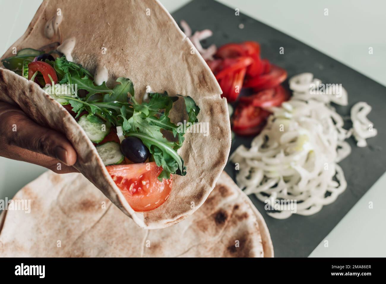 Mediterrane Pitta mit scharfem Huhn, Gurke, Tomaten, Salat und Mayo-Sauce Stockfoto
