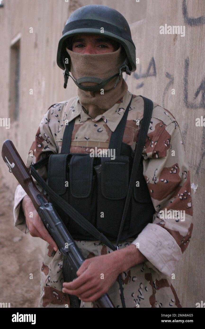 060316-M-0374B-002. [Complete] Szene Caption: Am 16. März 2006 steht ein irakischer Soldat mit 2. Bataillon, 4. Brigade, 1. Division, vor einem Haus, das von seinen Kameraden im Euphraten-Flussgebiet von Fallujah, Irak, durchsucht wird. Die irakischen Soldaten sind auf der Suche nach Waffenlagern und Gegenständen, die während der Operation California Dreaming zur Herstellung von Sprengkörpern verwendet werden könnten. RCT-5 wird zusammen mit dem IMEF zur Unterstützung der Operation Freiheit in der irakischen Provinz Anbar (MNF-W) eingesetzt, um die irakischen Sicherheitskräfte zu entwickeln und die Entwicklung der offiziellen Herrschaft von La zu erleichtern Stockfoto