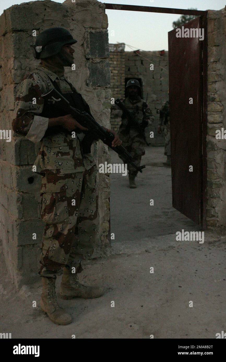 060316-M-0374B-011. [Complete] Szene Caption: Am 16. März 2006 steht ein irakischer Soldat mit 2. Bataillon, 4. Brigade, 1. Division, vor einem Haus, das von seinen Kameraden im Euphraten-Flussgebiet von Fallujah, Irak, durchsucht wird. Sie sind auf der Suche nach Waffenlagern und allen Gegenständen, die während der Operation California Dreaming zur Herstellung von Sprengkörpern verwendet werden könnten. RCT-5 wird zusammen mit dem MEF zur Unterstützung der Operation Freiheit in der irakischen Provinz Anbar (MNF-W) eingesetzt, um die irakischen Sicherheitskräfte zu entwickeln und die Entwicklung einer offiziellen Rechtsstaatlichkeit durch d zu erleichtern Stockfoto