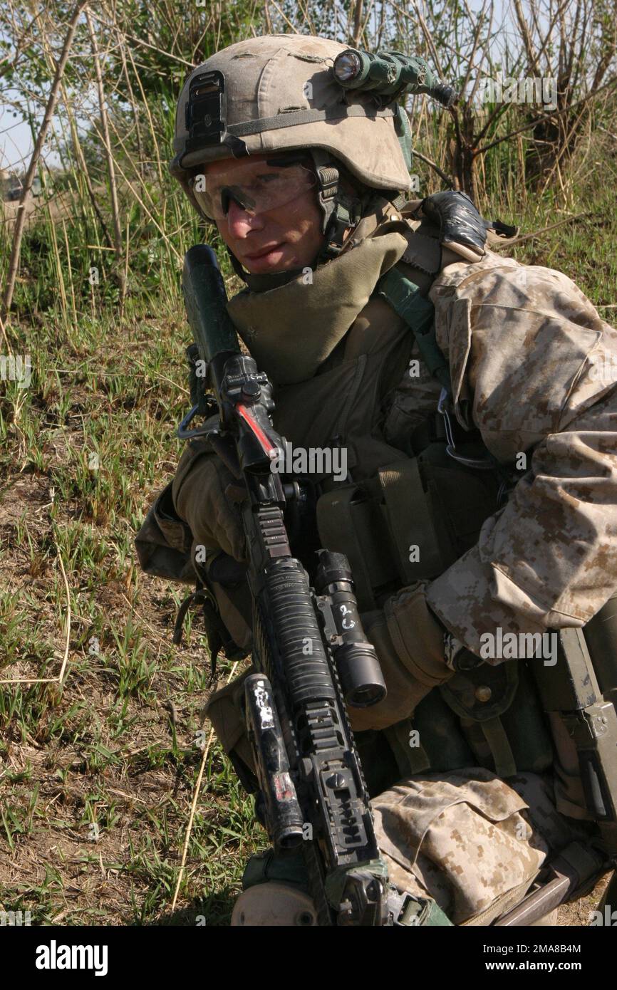 060317-M-0374B-003. [Complete] Szene Caption: Am 17. März 2006, ein Marine mit 3. Einheit, 2. Zug, Echo Company, 2. Bataillon, 6. Marines, Regimentalkampfteam 5, kniet während einer Pause auf Patrouille am Euphrates River in Fallujah, Irak, während Operation California Dreaming. Sie sind auf der Suche nach Waffenlagern und allen Gegenständen, die für improvisierte Sprengkörper (IEDs) verwendet werden könnten. RCT-5 wird zusammen mit dem IMEF zur Unterstützung der Operation Freiheit in der irakischen Provinz Anbar (MNF-W) eingesetzt, um die irakischen Sicherheitskräfte zu entwickeln und die Entwicklung einer offiziellen Rechtsstaatenbekämpfungsaktion zu erleichtern Stockfoto