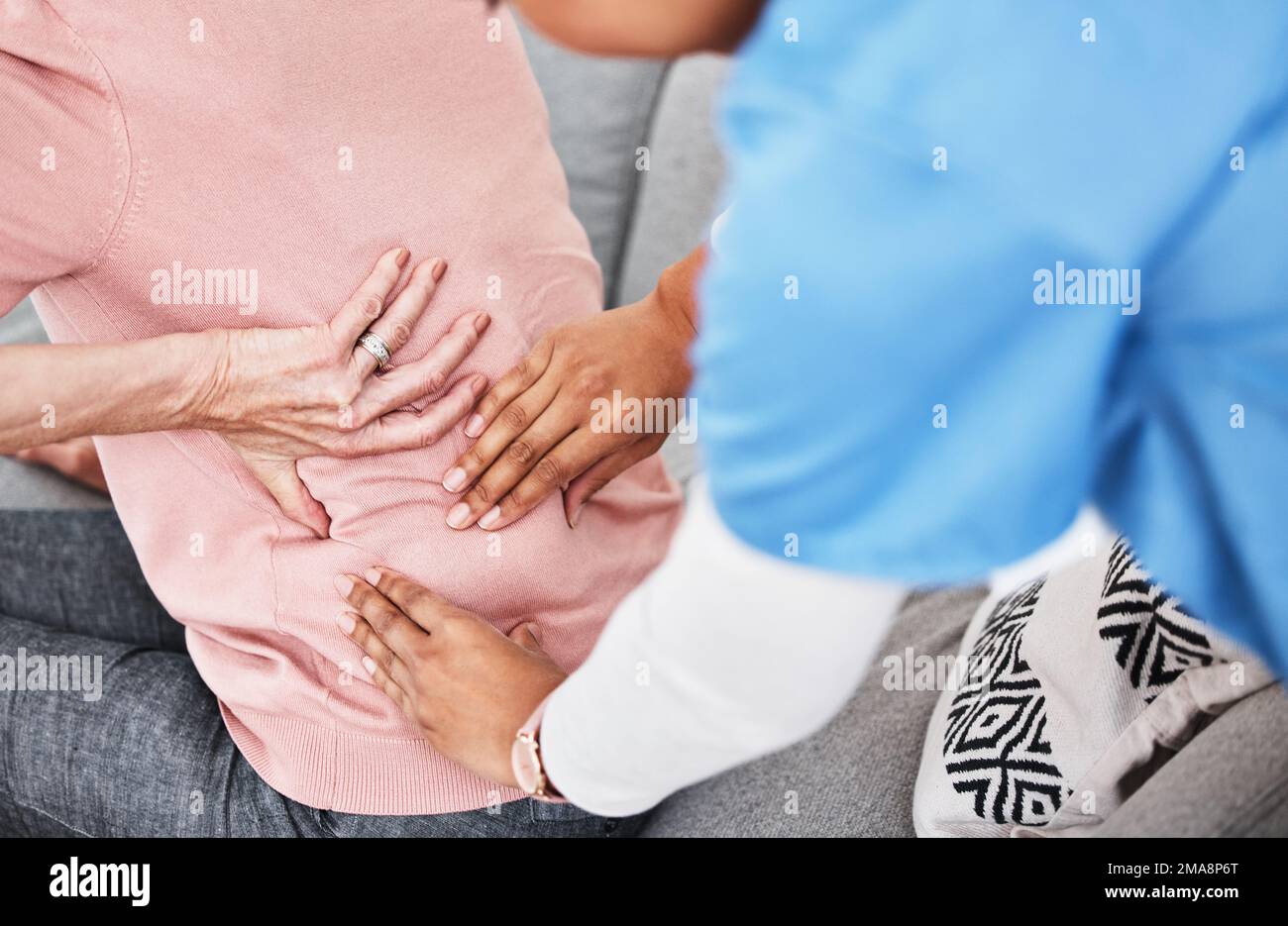 Mal sehen, ob wir etwas von dieser Spannung lösen können. Eine Krankenschwester massiert ihre Patienten zurück. Stockfoto