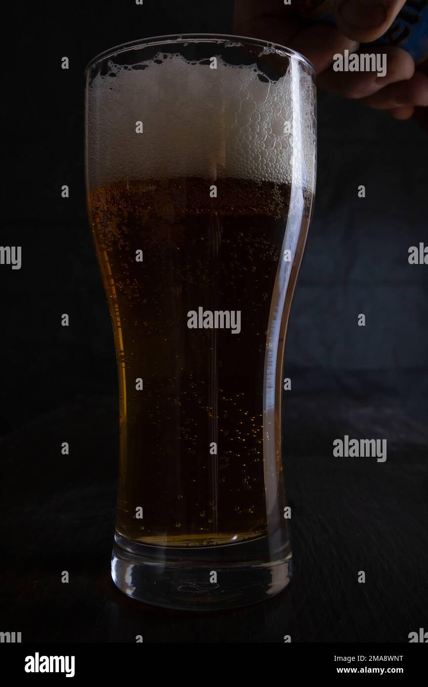 Ein Glas Bier vor einem dunklen Hintergrund. Stockfoto