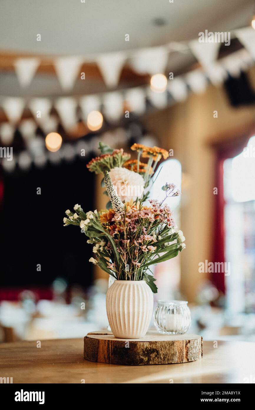 Schöne bunte Blumen in weißer Vase als Hochzeitsdekoration Stockfoto