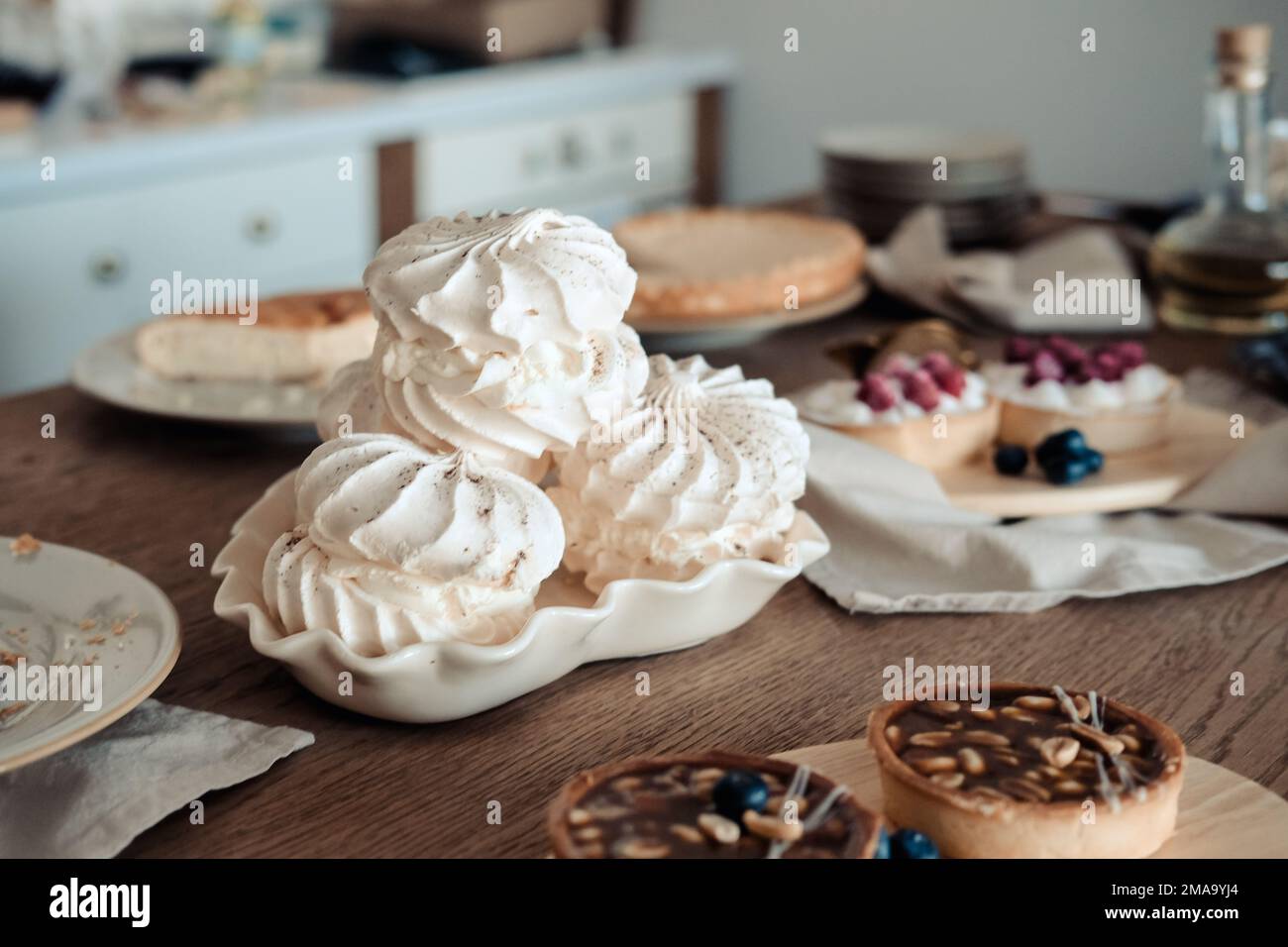 Weißer, luftiger Baiser-Kuchen auf dem Festtisch, in der Küche. Stockfoto