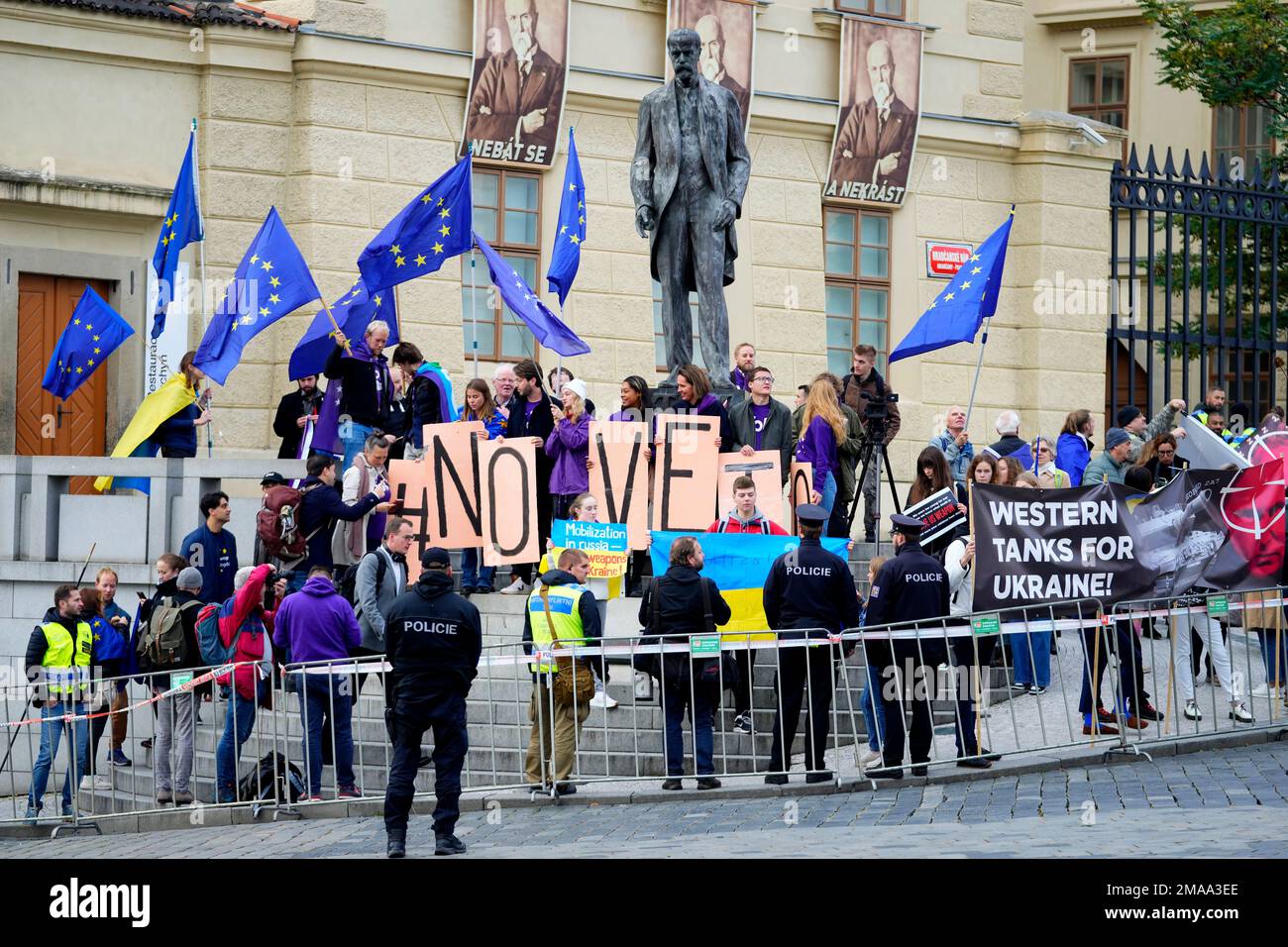 Protestors hold EU flags and banners as they demonstrate outside of an EU Summit at Prague Castle in Prague, Czech Republic, Friday, Oct 7, 2022. European Union leaders converged on Prague Castle Friday to try to bridge significant differences over a natural gas price cap as winter approaches and Russia's war on Ukraine fuels a major energy crisis. Sign reads "No Veto". (AP Photo/Petr David Josek) Stockfoto