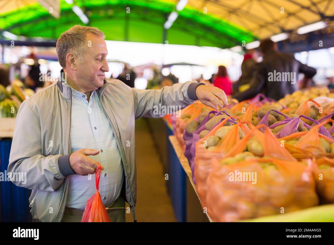 Mann, der Kartoffeln auf dem Markt kauft Stockfoto