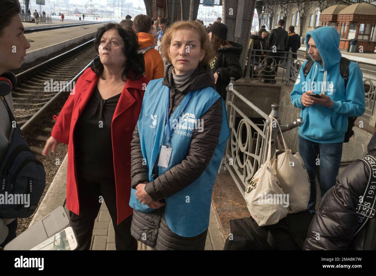15.04.2022, Ukraine, Oblast, Lemberg – Ukrainische Kriegsflüchtlinge werden auf dem Bahnsteig am Hauptbahnhof von Freiwilligen empfangen und betreut. Attenti Stockfoto