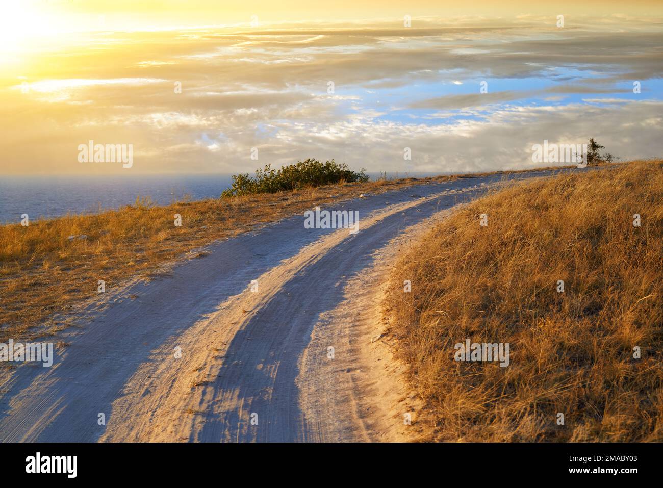 Eine scharfe Kurve einer unbefestigten Straße nahe der Schwarzmeerküste im Dhangul-Trakt bei Sonnenuntergang. Krim, Ukraine Stockfoto