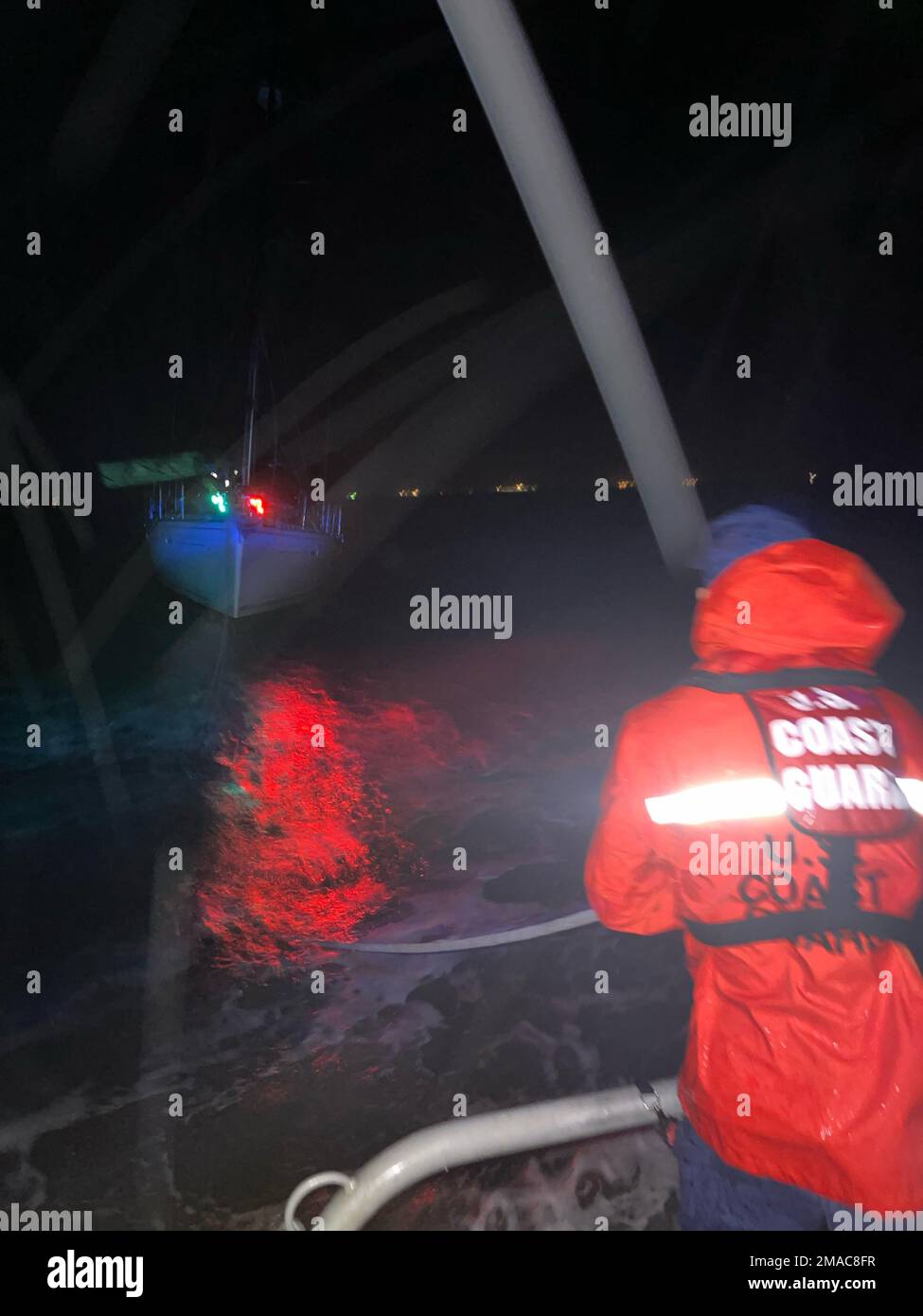 Besatzungsmitglieder an Bord eines 45-Fuß-Response Boat-Medium von der Küstenwache Galveston schleppten am 25. Mai 2022 ein behindertes 50-Fuß-Segelschiff in der Nähe von Galveston, Texas. Die Küstenwache erhielt einen Anruf über den UKW-FM-Kanal 16 um 3 Uhr morgens vom Betreiber des Schiffes, der besagte, dass der Mast des Segelbootes beschädigt wurde und die Motoren 30 Meilen vor der Küste defekt waren. 45 rbm, SAR, SCHLEPPTAU, USCG, galveston, Segelboot, Stockfoto