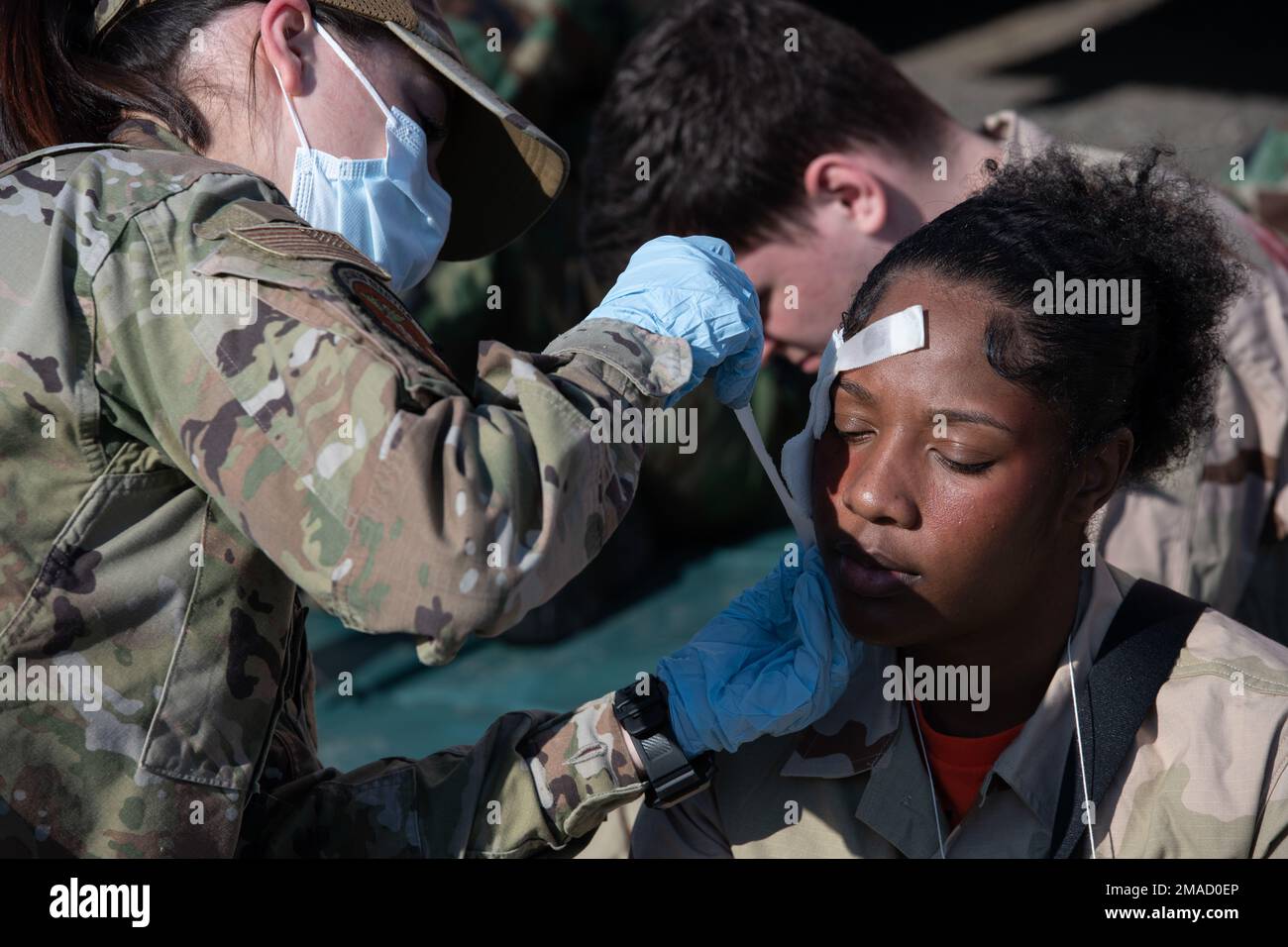 Ein Air Force-Verletzten-Rollenspieler, richtig, erhält medizinische Hilfe während der Teilnahme an Mission Assurance Übung 22-6 auf der Joint Base Elmendorf-Richardson, Alaska, 25. Mai 2022. MAE 22-6 testete nach einem Flugzeugunfall die Notfalleinsatzkapazitäten von JBER. Stockfoto