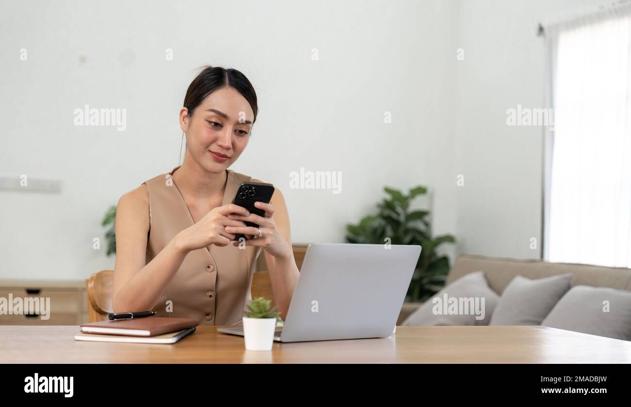 asiatische Frau, die ihr Handy benutzt, während sie eine E-Mail oder soziale Medien im Internet abruft. Finanzkonzept der Rechnungslegung Stockfoto
