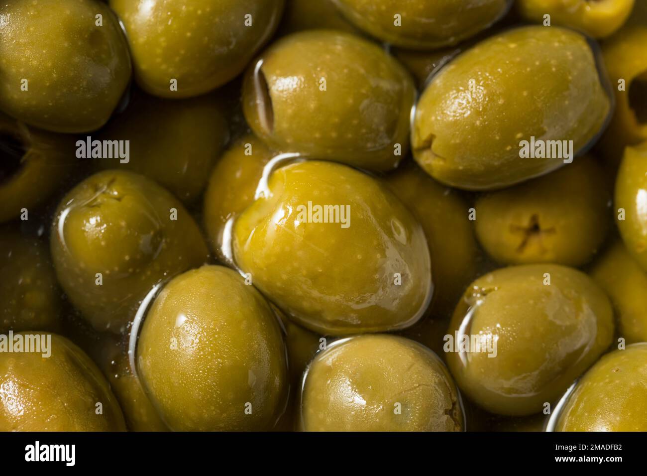 Rohe, grün, organisch marinierte Oliven in Öl Stockfoto