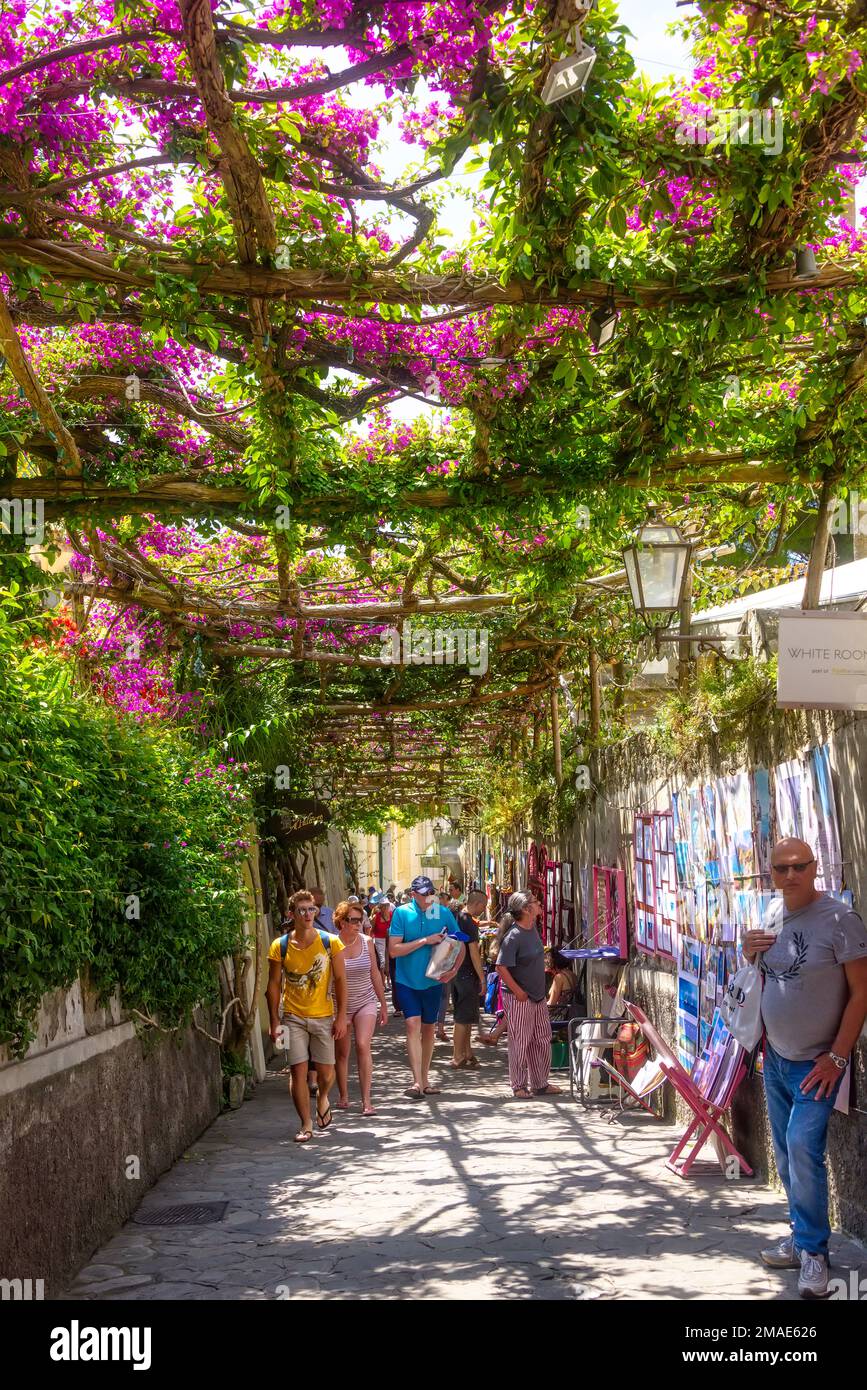 Positano, Italien - 11. Juni 2016: Blühende Gassen gefüllt mit Shoppern und Touristen an warmen Sommertagen. Stockfoto