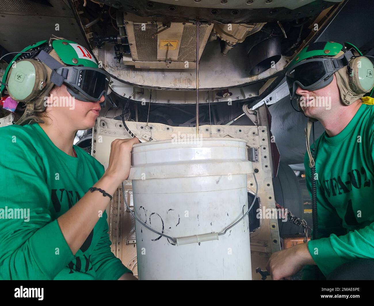 220526-N-IR734-1011 PHILIPPINE SEA (26. Mai 2022) Aviation Machinist's Mate 2. Class Selena Lara, Left, aus Sacramento, Kalifornien, Und Aviation Machinist's Mate Airman Peyton Marsh, aus Pueblo, Colorado, angeschlossen an die Diamondbacks des Streikfighter Squadron (VFA) 102, lässt Öl aus einem in der Flugzeugzelle montierten Nebenantrieb auf einem F/A-18E Super Hornet in der Hangarbucht der USA ab Der einzige vorwärtsgesetzte Flugzeugträger der Navy USS Ronald Reagan (CVN 76). Ronald Reagan, das Flaggschiff der Carrier Strike Group 5, stellt eine kampfbereite Truppe bereit, die die Vereinigten Staaten schützt und verteidigt und unterstützt Stockfoto